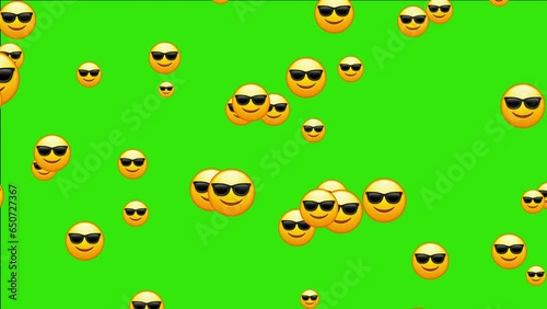 Cool emoticon. Smiling face with sunglasses emoji. Happy smile person wearing dark glasses. Animated falling emojis. Social media icons symbol animation with green screen background.