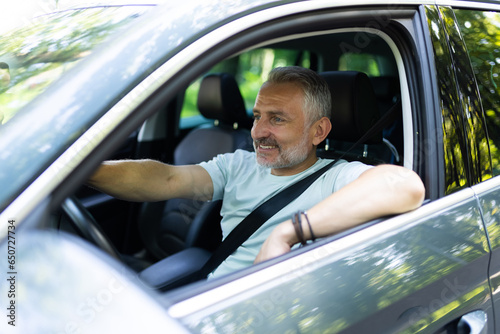 Фотография Middle aged man driving a car in city
