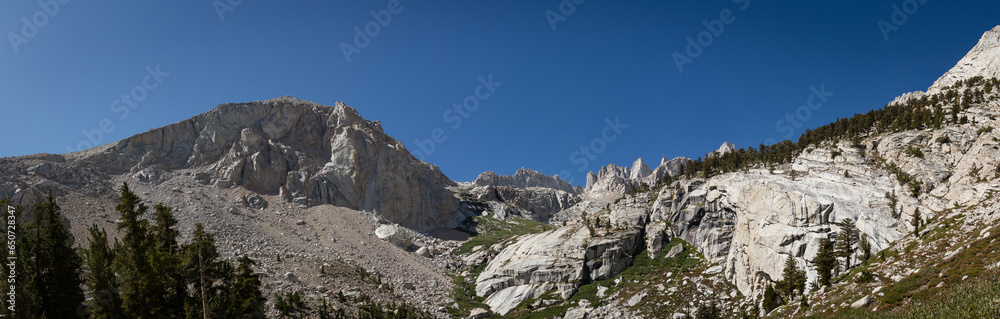 Panorama view white granite stone of Mount Whitney, trees and blue sky, usa