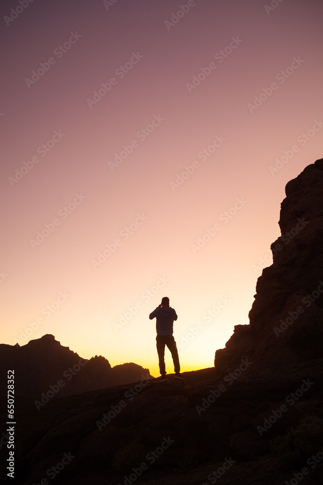 silhouette of a person on the top of a mountain at the sunset