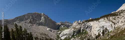 Panorama view white granite stone of Mount Whitney, trees and blue sky, usa