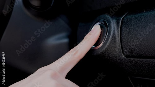 a modern and convenient keyless ignition system. woman's index finger press the circular button to start the engine.