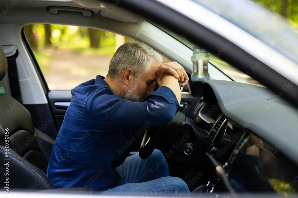 Mid age man sitting inside car is very upset and stressed Mid age man sitting inside car is very upset and stressed