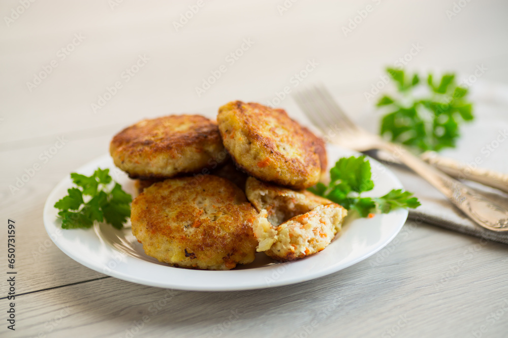 Cooked fried fish cutlets in a plate with herbs. Cooked fried fish cutlets in a plate with herbs.