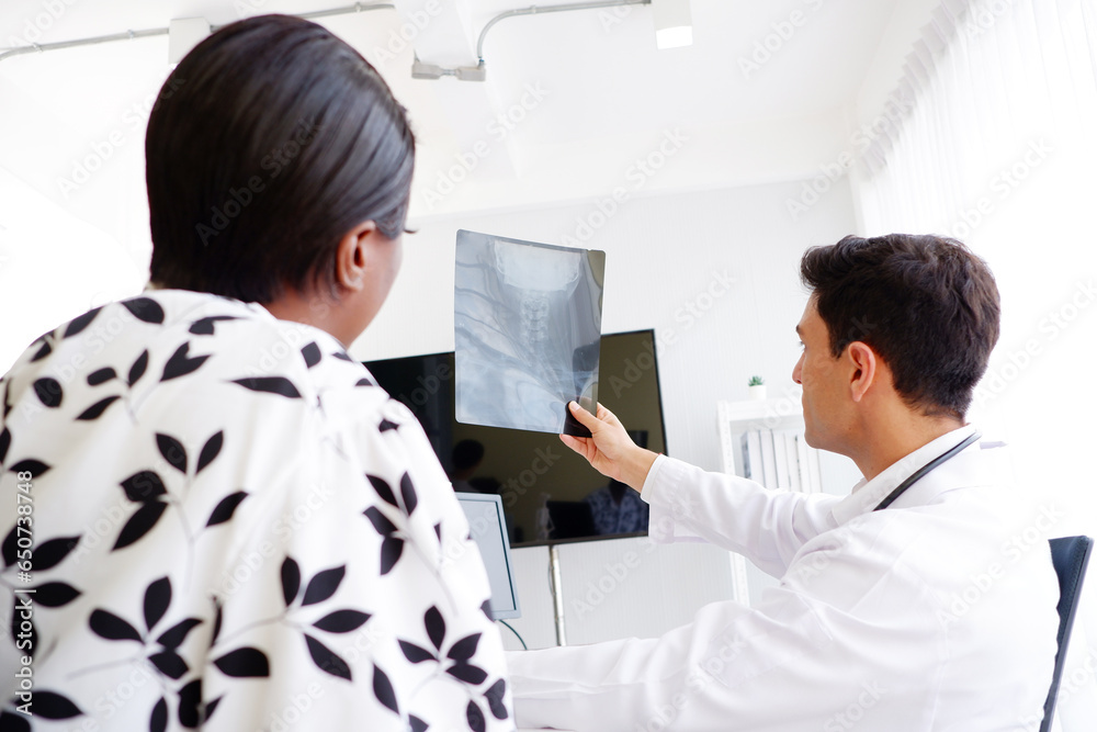 Obraz premium Doctor and patient look at bone x-ray film.