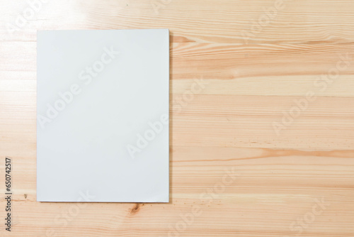 Mockup of blank book cover white on textured wooden background. 
Empty magazine template to your design. 
top view.  
