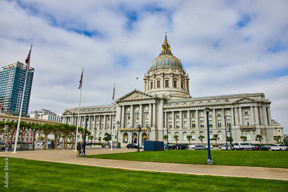 San Francisco city hall with pedestrians on sidewalk and cloudy blue sky overhead