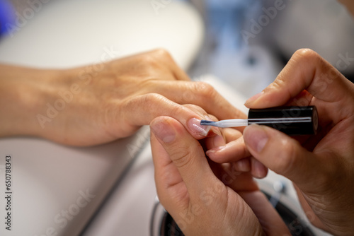 Nail care procedure in a beauty salon. Female hands and tools for manicure  process of performing manicure in beauty salon. Concept spa body care. Gloved hands of a skilled manicurist cutting cuticles