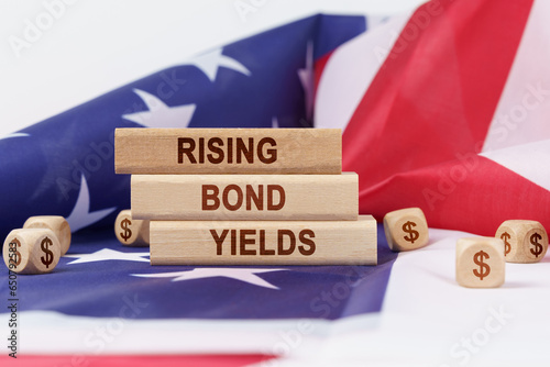On the US flag and wooden plates with the inscription - rising bond yields photo