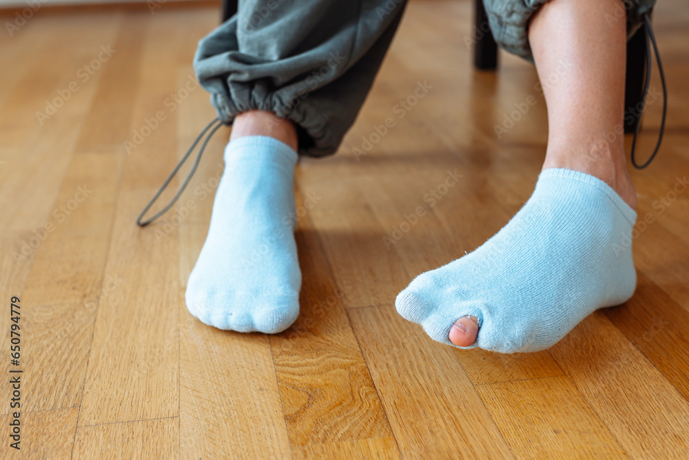 holey sock on teenager's foot - obrazy, fototapety, plakaty 