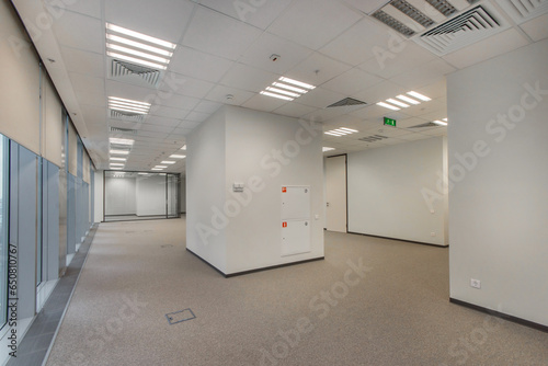 An empty spacious office space with light walls, prepared for work.