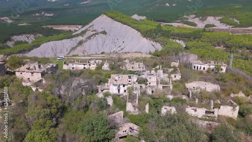 Aerial drone video of an abandoned town named Esco in North Spain, next to a large lake.