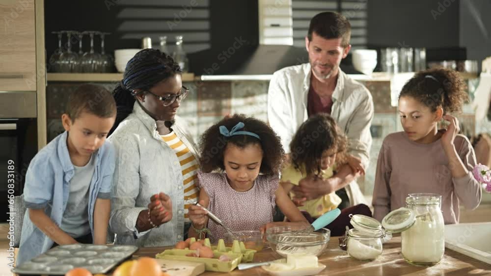 Young interracial blended family baking and being messy in the kitchen at home