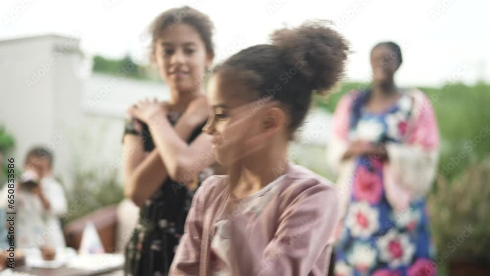 Young interracial blended family dancing and having fun at the mothers birthday party on the patio of their house Young interracial blended family dancing and having fun at the mothers birthday party on the patio of their house