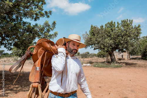 western man grooming and feeding his horses on his ranch