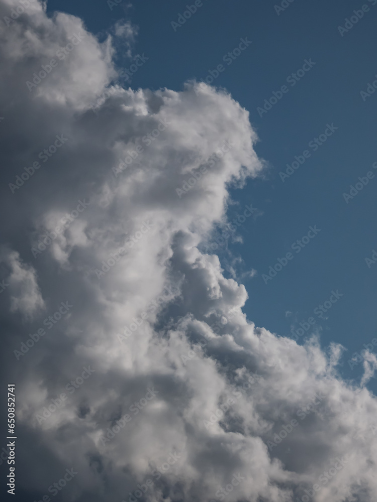 View of blue sky with fluffy white and dark clouds in a sunny day. Background of dark sky sunlit with beautiful white clouds View of blue sky with fluffy white and dark clouds in a sunny day. Background of dark sky sunlit with beautiful white clouds