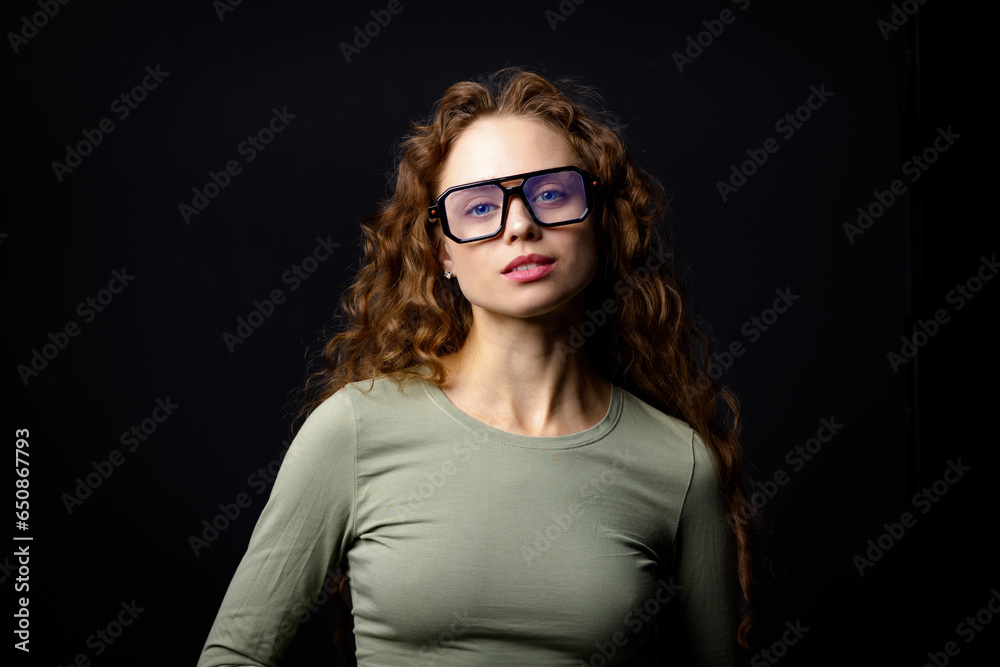 Young serious woman wearing glasses looking at camera with joyful smile Young serious woman wearing glasses looking at camera with joyful smile