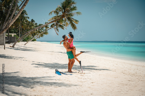 young attractive couple with snorkeling gear, couple enjoy snorkeling in the ocean, coral watching and active vacation