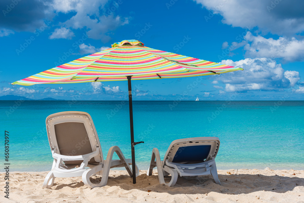 Beach umbrella in foreground with a turquoise cystal water of caribbean sea in background