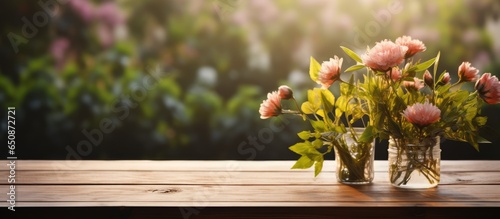 Morning garden flower background with wood table top for product display or design layout © AkuAku