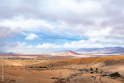 scenic landscape in Fuerteventura vith view to the mountains under cloudy sky