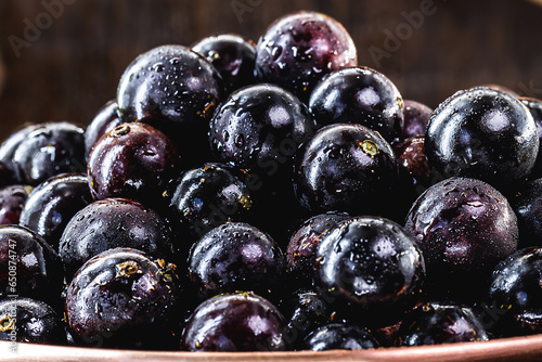 Jabuticaba. Brazilian and South American tropical fruits, in a copper pot on a rustic table photo