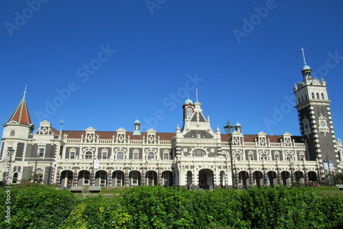 Low angle shot of green bushes against the Dunedin Railway Station in New Zealand