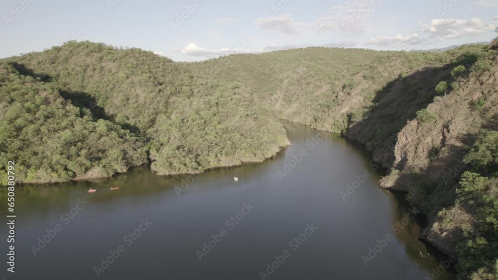 Drone view over a river flowing between forested landscapes Drone view over a river flowing between forested landscapes