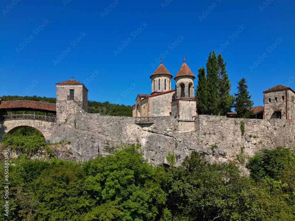 an old castle sits on the edge of a hill near some trees: Georgia, Motsameta Monastery