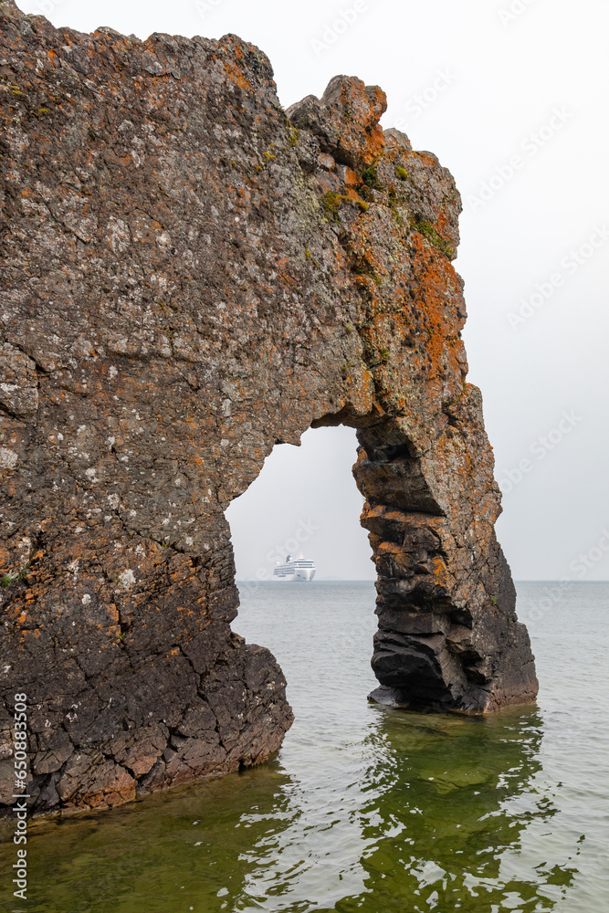Glimpse of a Cruise Ship on a Foggy, Smoky Day on Lake Superior Through the Arch of the Sea Lion Arched Rock Formation