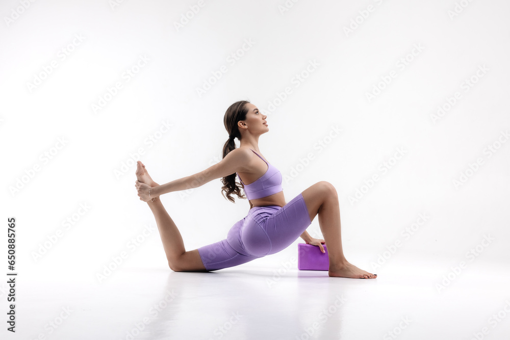 Close-up woman doing stretching exercises on a white background. Foam block Fitness Equipment. Female doing stretching exercises on a white background. Foam Roller Massage Ball, Fitness Equipment Close-up woman doing stretching exercises on a white background. Foam block Fitness Equipment. Female doing stretching exercises on a white background. Foam Roller Massage Ball, Fitness Equipment