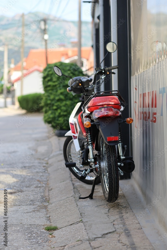 Vibrant red motorcycle parked along the curb of a quiet residential street