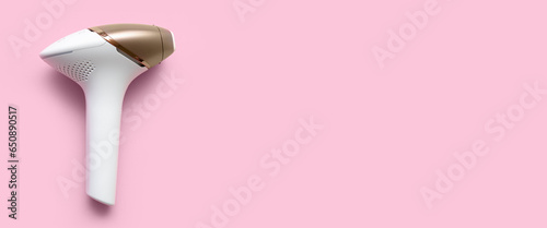 Modern photoepilator on pink background with space for text