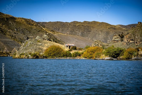 Old gold miners' shack on the shore of the Clutha River in New Zealand photo