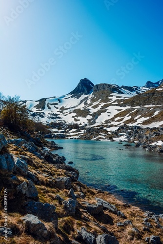 a lake that is surrounded by rocks and snow covered mountains