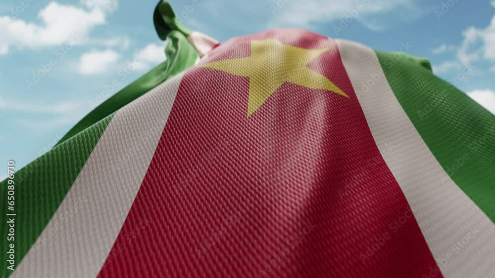 Wavy flag of Suriname blowing in the wind in slow motion. Waving official Suriname flag team symbol abstract vertical background. Blue sky with clouds. World countries flying flags concept