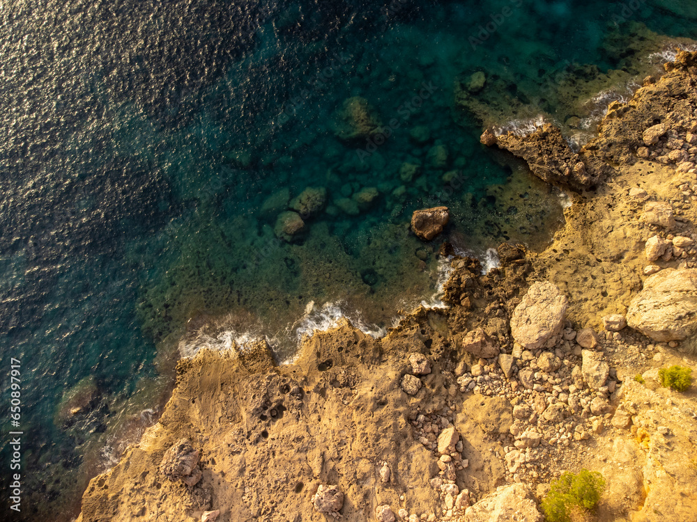 coastline in an aerial view  . mediterranean blue water and orange rocks