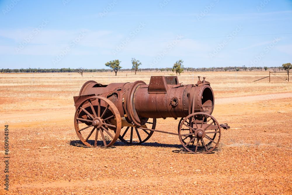 An old rusted farm steam engine from a bygone era, now abandoned and on display in outback country, Australia.