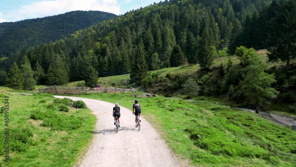 Two cyclists are riding gravel bikes in the scenic beauty of the mountains.Cycling on gravel roads or off-road.Active adventures and the concept of travel by bike.Gravel bike riding in nature. Two cyclists are riding gravel bikes in the scenic beauty of the mountains.Cycling on gravel roads or off-road.Active adventures and the concept of travel by bike.Gravel bike riding in nature.