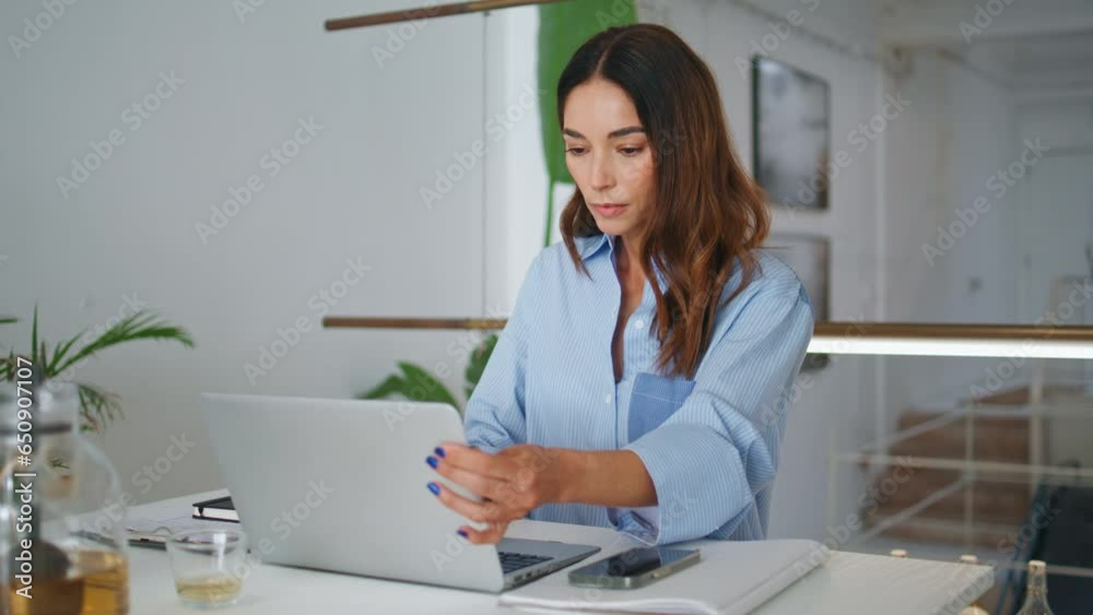 Attractive woman browsing laptop in contemporary office. Focused project manager