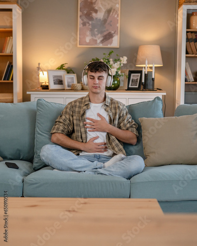 One teen man doing guided meditation yoga self care practice at home