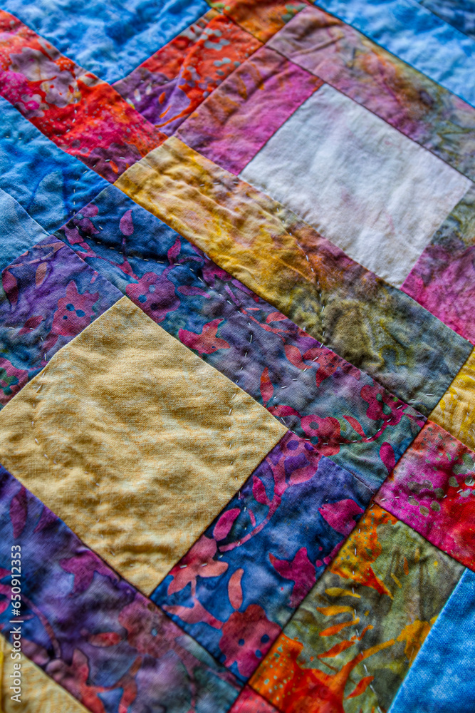 Detail of colorful quilt made in block pattern. Detail of colorful quilt made in block pattern.