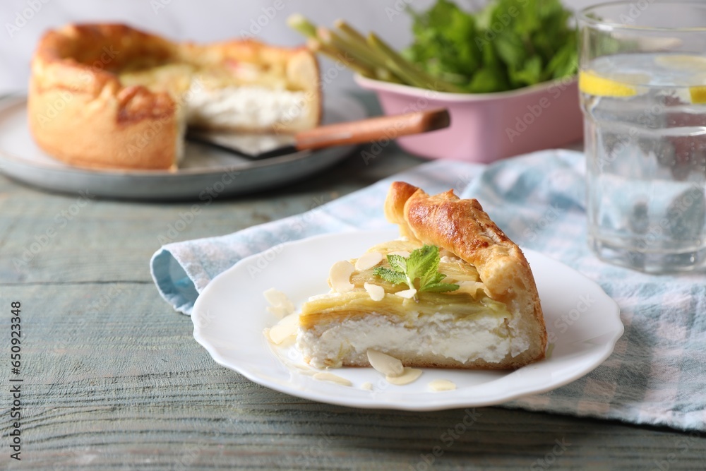 Freshly baked rhubarb pie with cream cheese, mint leaves and almond flakes on grey wooden table Freshly baked rhubarb pie with cream cheese, mint leaves and almond flakes on grey wooden table