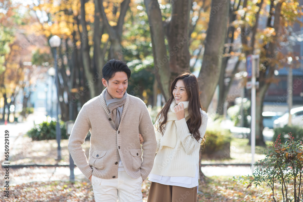 晩秋の並木道を散歩する20代カップル 晩秋の並木道を散歩する20代カップル