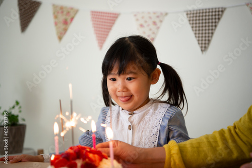 ケーキのろうそくを見ている女の子 photo
