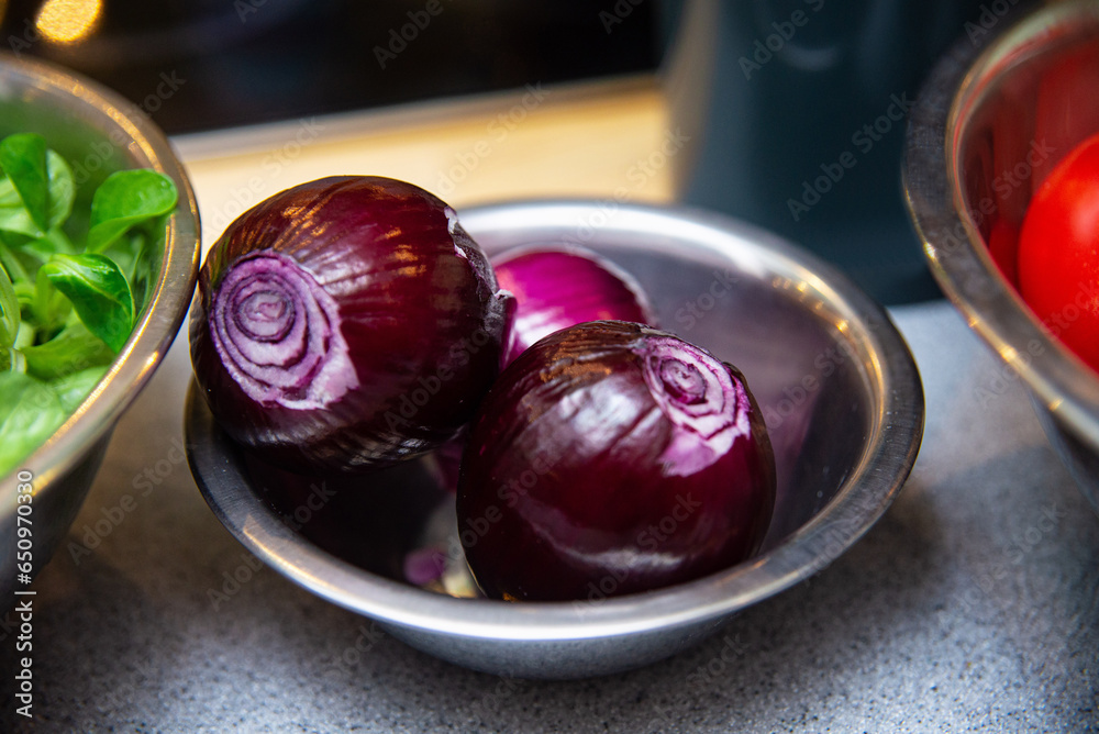 Fresh red onions in metal bowl on kitchen table. Selective focus. Fresh red onions in metal bowl on kitchen table. Selective focus.