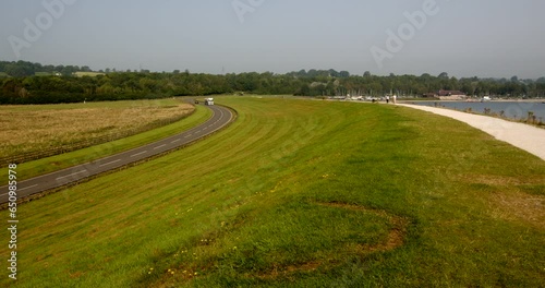 Looking up Carsington water dam, with the dam road to the left frame with traffic photo