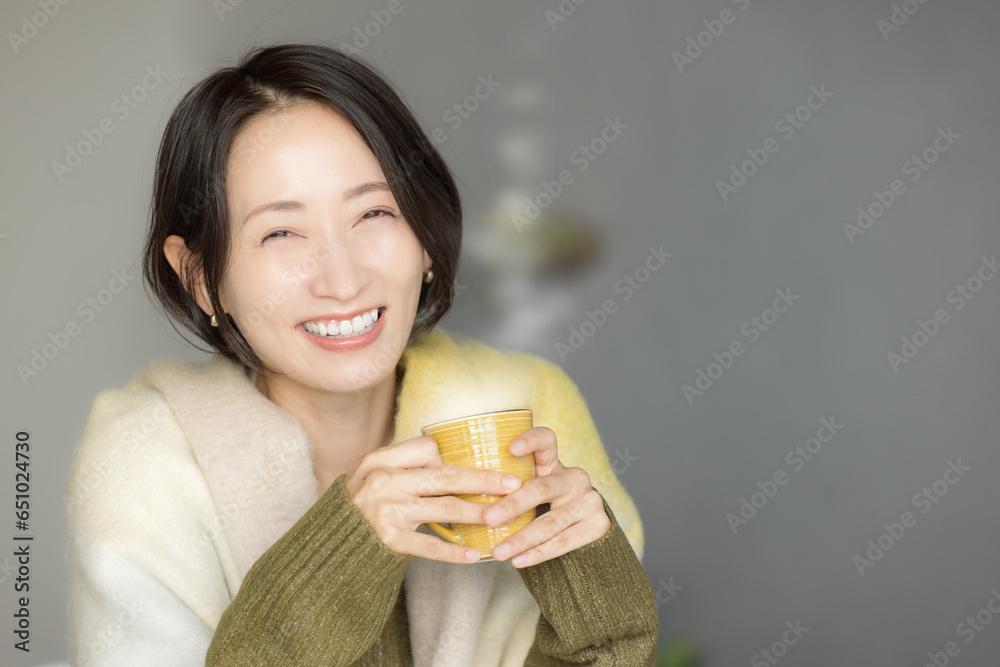 Asian (Japanese) woman drinking hot coffee, fall/winter. Asian (Japanese) woman drinking hot coffee, fall/winter.