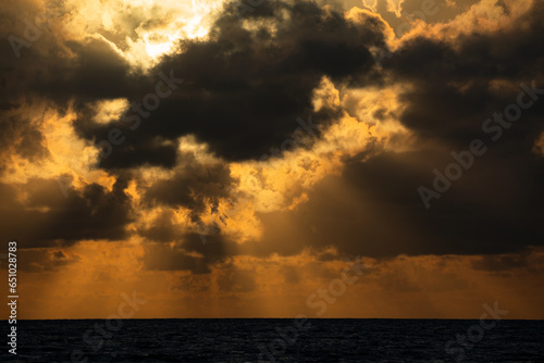 The sun s rays shine through the clouds  creating beautiful images above sea level.Beautiful  colorful  sunrise over the sea