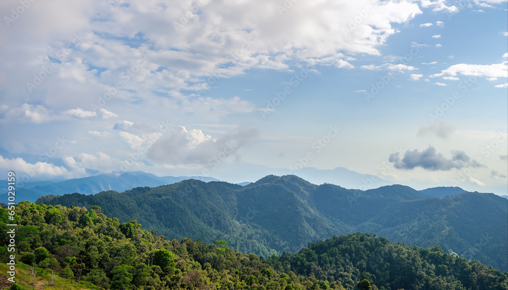 Amazing wild nature view of layer of mountain forest landscape with cloudy sky. Natural green scenery of cloud and mountain slopes background. Maehongson,Thailand. Panorama view
